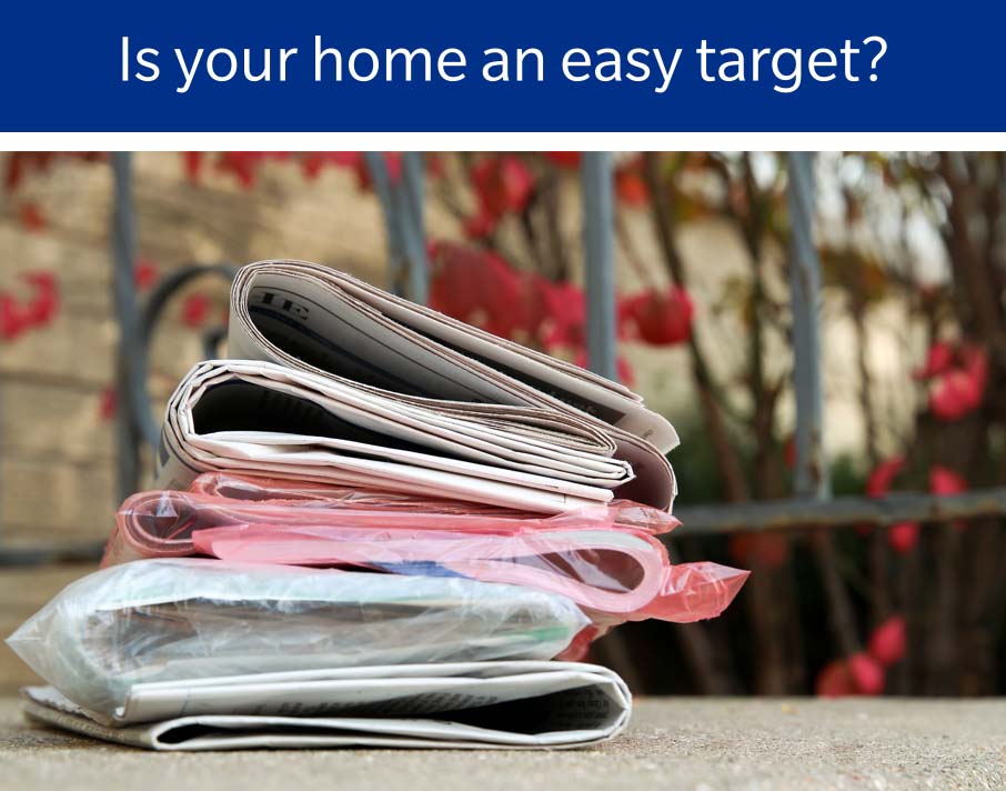 Newspapers piled on doorstep with text caption: Is your home an easy target? 