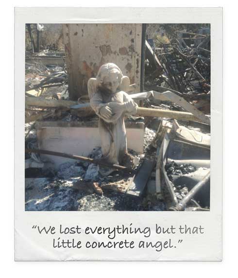 Concrete angel yard statue standing in aftermath of wildfire 