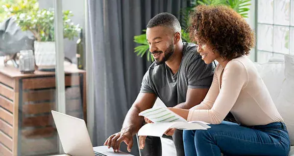 man and woman review computer screen