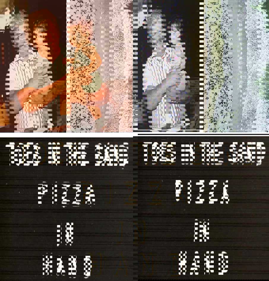 Little girl with grandfather, coastline loaded with bathers, letter board that says: Toes in the sand, pizza in hand   